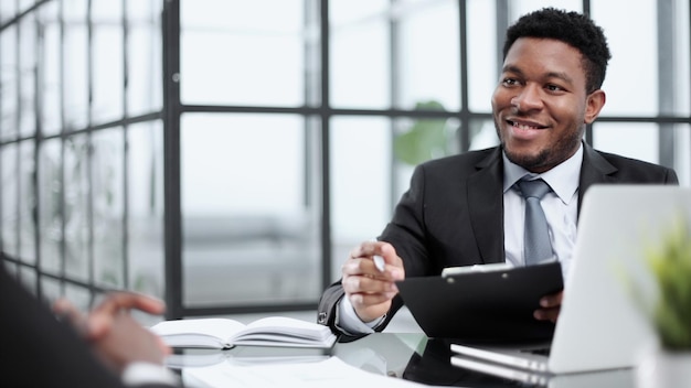 Uomo che lavora in ufficio utilizzando il portatile al lavoro soddisfatto del risultato ottenuto