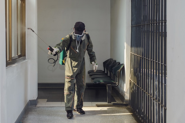 Uomo che lavora per disinfettare un edificio