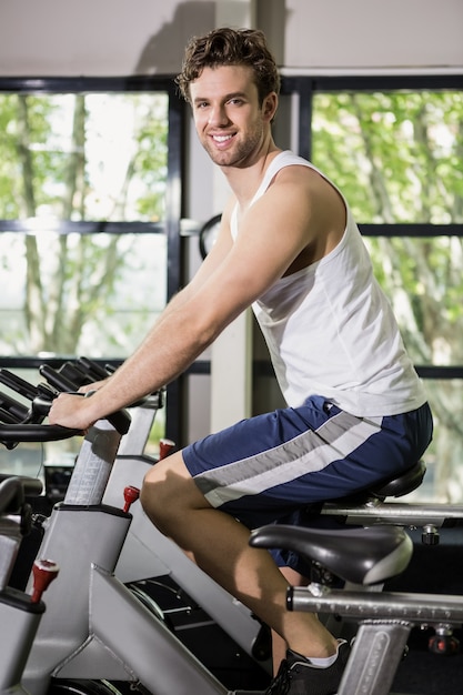 Uomo che lavora su cyclette a lezione di spinning