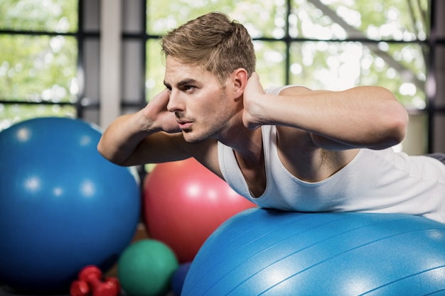 Uomo che lavora sulla palla fitness