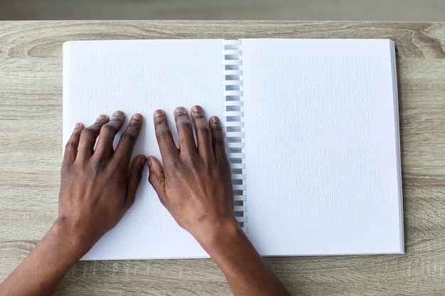 Uomo che legge il libro in Braille vista dall'alto