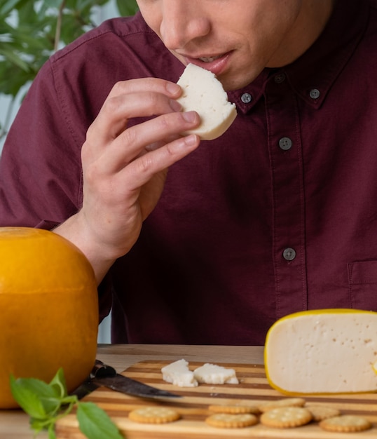 Uomo che mangia o prova un pezzo di formaggio di capra, cibo tradizionale olandese nei Paesi Bassi.