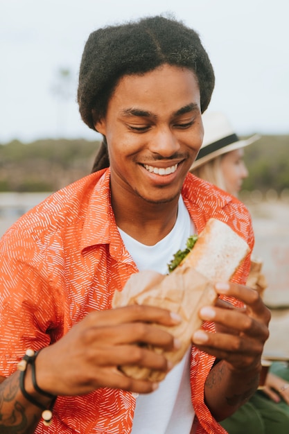 uomo che mangia sulla spiaggia