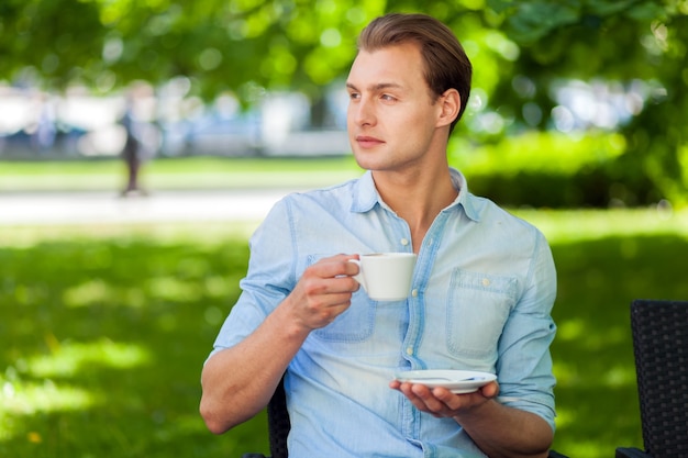 Uomo che mangia una tazza di caffè all&#39;aperto