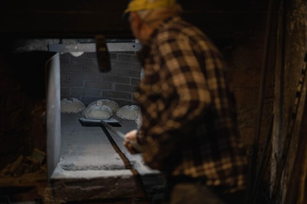 Uomo che mette il pane nel forno