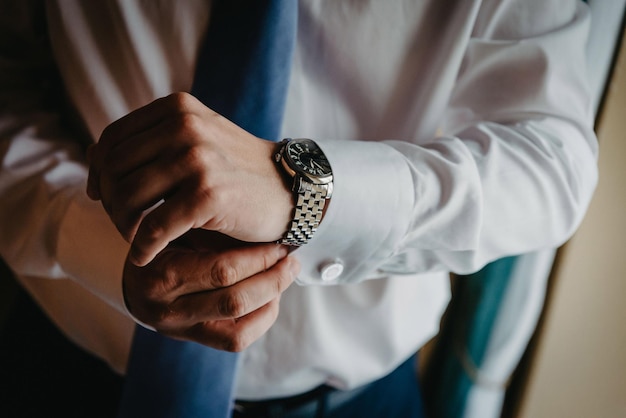 Uomo che mette l'orologio sullo sposo che si prepara al mattino