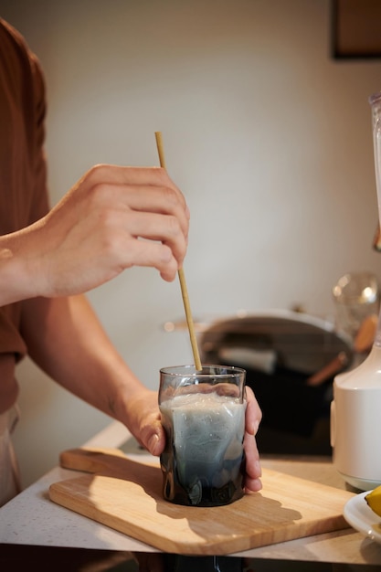 Uomo che mette la cannuccia in vetro con il frullato