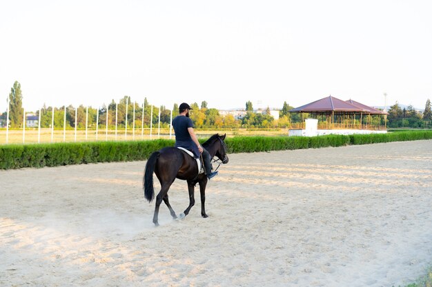 Uomo che monta un cavallo in pista