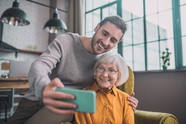 Uomo che mostra a sua madre come utilizzare lo smartphone