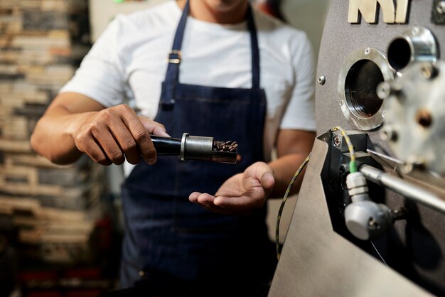 Uomo che mostra la sonda del caffè tostato