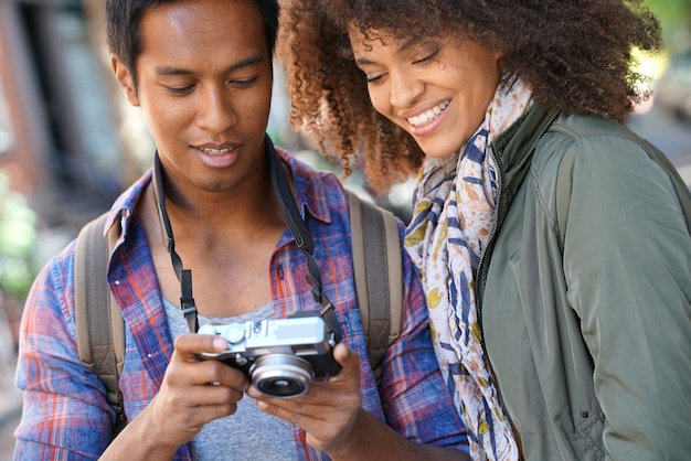 Uomo che mostra le immagini alla ragazza sullo schermo della fotocamera