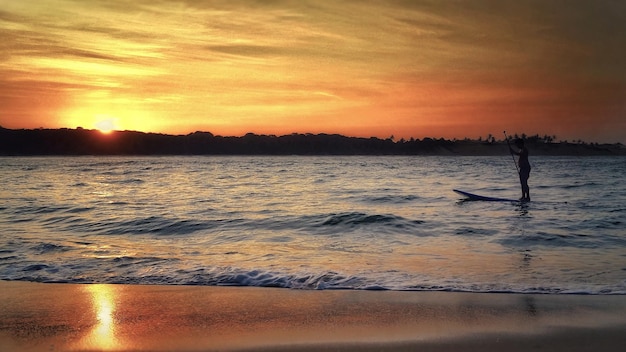 uomo che naviga al tramonto sulla spiaggia Spiaggia di Pipa