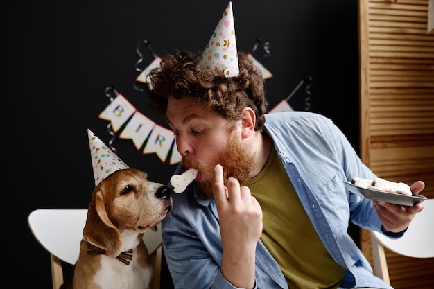 Uomo che nutre il suo cane con i biscotti