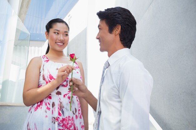 Uomo che offre una rosa rossa alla fidanzata