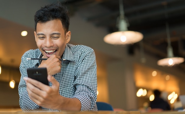 Uomo che osserva sul dispositivo del telefono cellulare