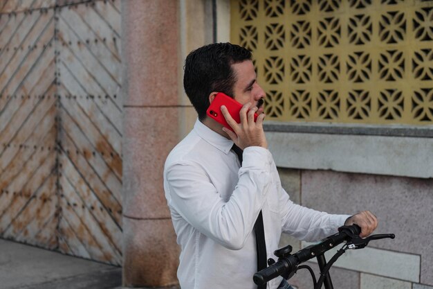 Uomo che parla al cellulare in piedi su uno scooter per strada