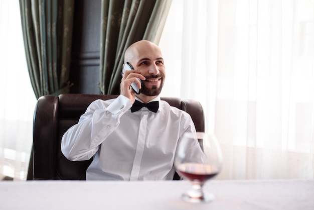 Uomo che parla al telefono al ristorante.