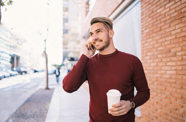 Uomo che parla al telefono all'aperto.