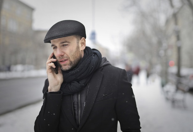 Uomo che parla al telefono in inverno