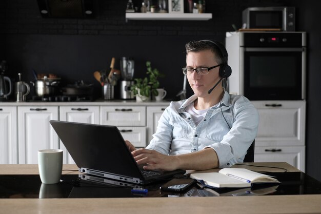 Uomo che per mezzo del computer portatile per lavorare online a casa