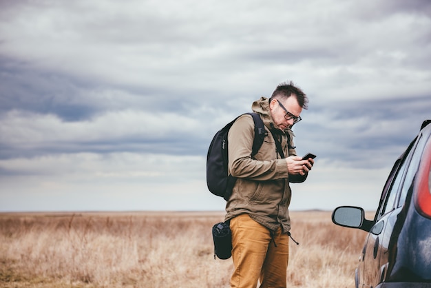 Uomo che per mezzo dello Smart Phone all'aperto