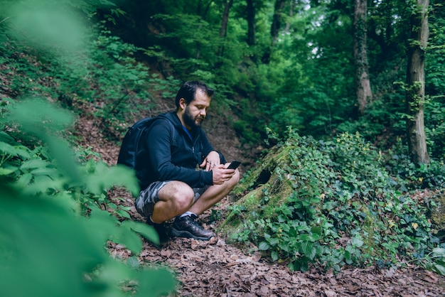 Uomo che per mezzo dello Smart Phone per navigare nella foresta