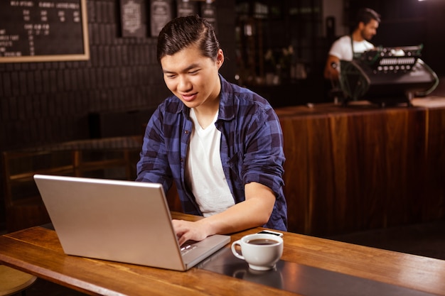 Uomo che per mezzo di un computer portatile