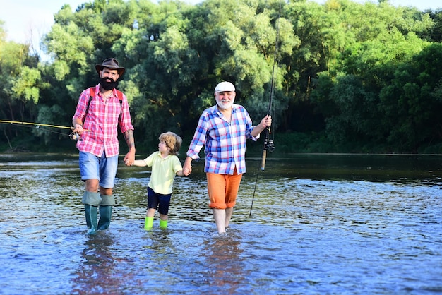 Uomo che pesca in famiglia Padre figlio e nonno che si rilassano insieme Nonno e padre con un bambino carino stanno pescando