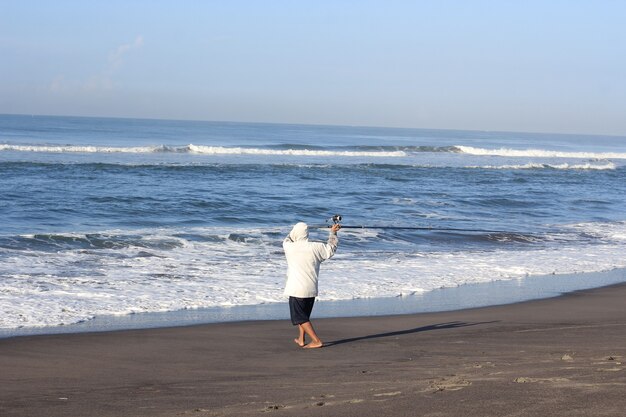 Uomo che pesca in mare dalla spiaggia