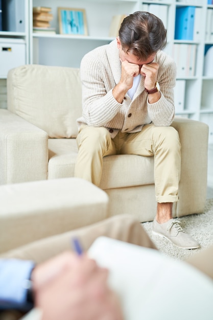 Uomo che piange in terapia