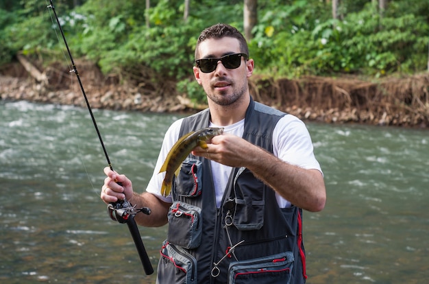 Uomo che pratica la pesca sportiva nel fiume