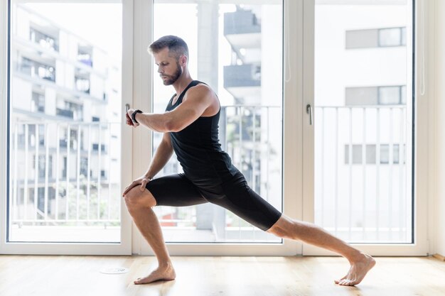 Uomo che pratica yoga a casa sua