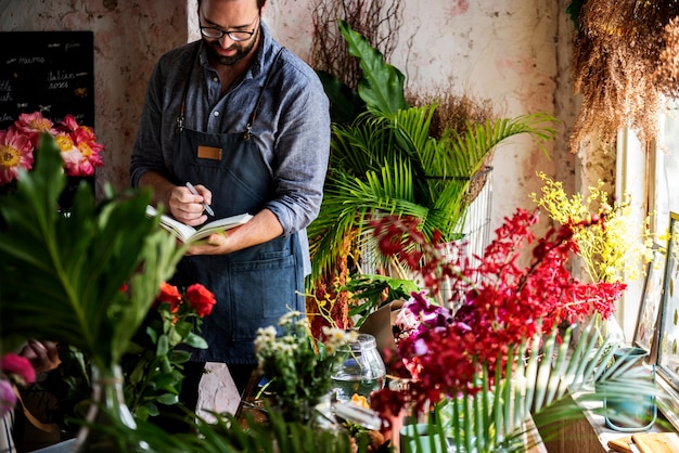 Uomo che prende appunti in un negozio di fiori