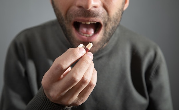 Uomo che prende la pillola della medicina a casa