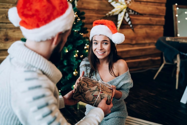 Uomo che presenta un regalo di Capodanno a una bella donna felice