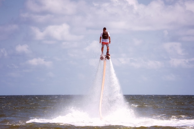 Uomo che propone al flyboard estremo dell'acqua.