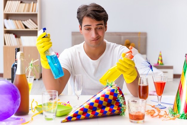 Uomo che pulisce la casa dopo la festa di Natale