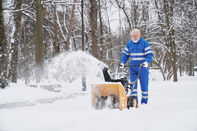 Uomo che pulisce la neve con lo snowblover.