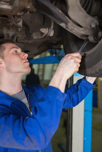 Uomo che regola la gomma dell&#39;automobile con la chiave