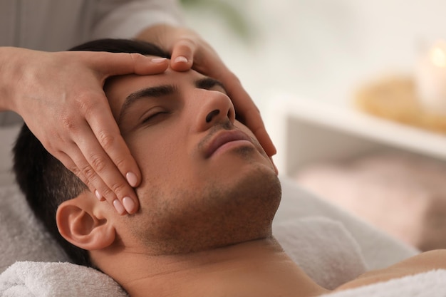 Uomo che riceve massaggio facciale nel primo piano del salone di bellezza