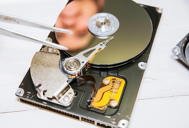 Uomo che ripara il disco rigido All'interno dei dettagli del vecchio personal computer Pinze PC rotte nelle mani
