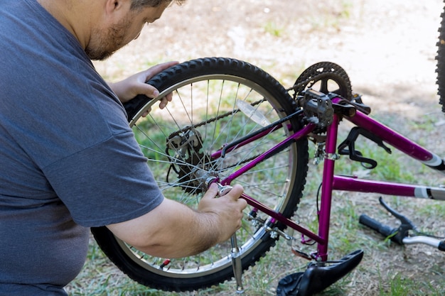 Uomo che ripara le biciclette, un bel meccanico di biciclette in fase di lavoro