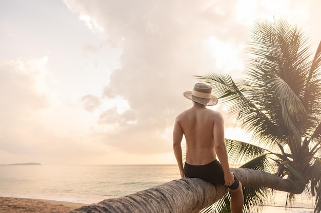 Uomo che riposa su una palma da cocco inclinata