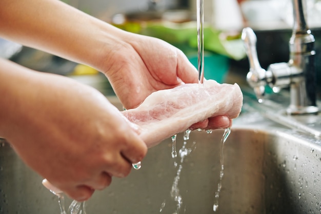 Uomo che risciacqua la carne