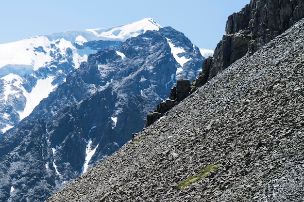 Uomo che scala una montagna ripida Buona immagine per la lotta avventurosa e la foto della storia di successo Alpinismo amatoriale contro il cielo blu