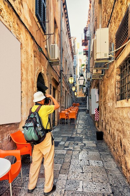 Uomo che scatta foto di strada stretta nella città vecchia di Dubrovnik, Croazia