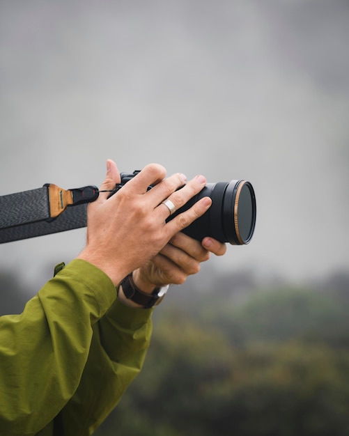 Uomo che scatta foto in una foresta nebbiosa