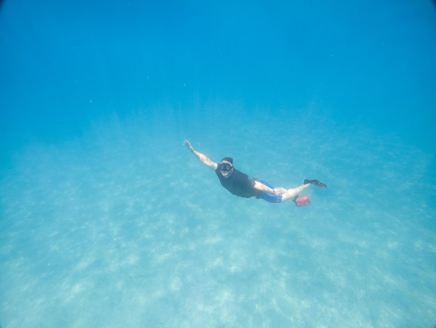 Uomo che scatta foto selfie sott'acqua in vacanza mare estate maschera subacquea