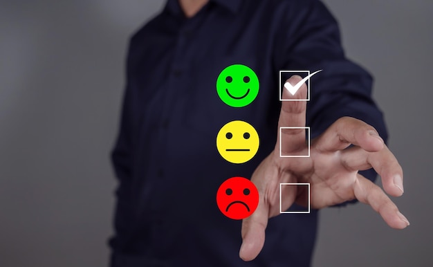 Uomo che sceglie l'icona verde felice sullo schermo tattile virtuale in un sondaggio di soddisfazione dello smartphone valutazione della salute mentale valutazione del feedback e recensioni positive dei clienti