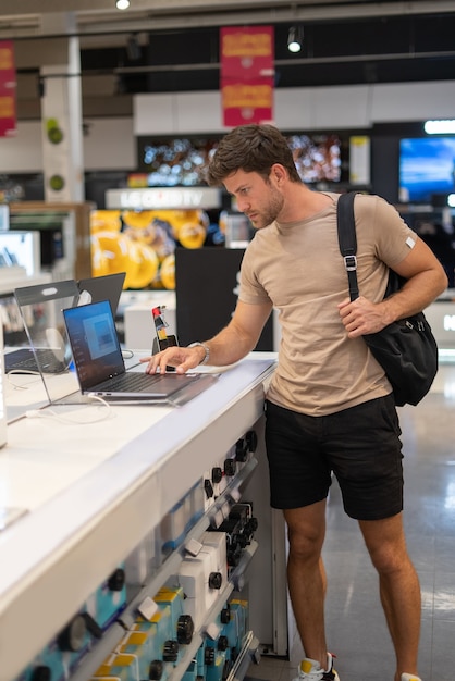 Uomo che sceglie un nuovo laptop in negozio